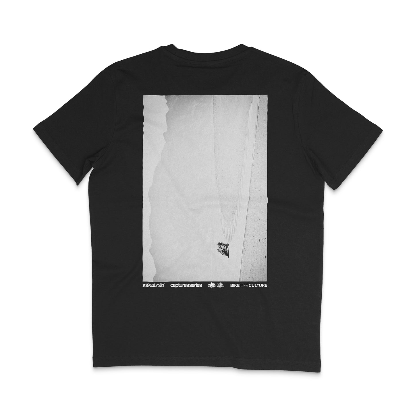 Backside of a black t-shirt with a large photo backprint of a biker on a racetrack