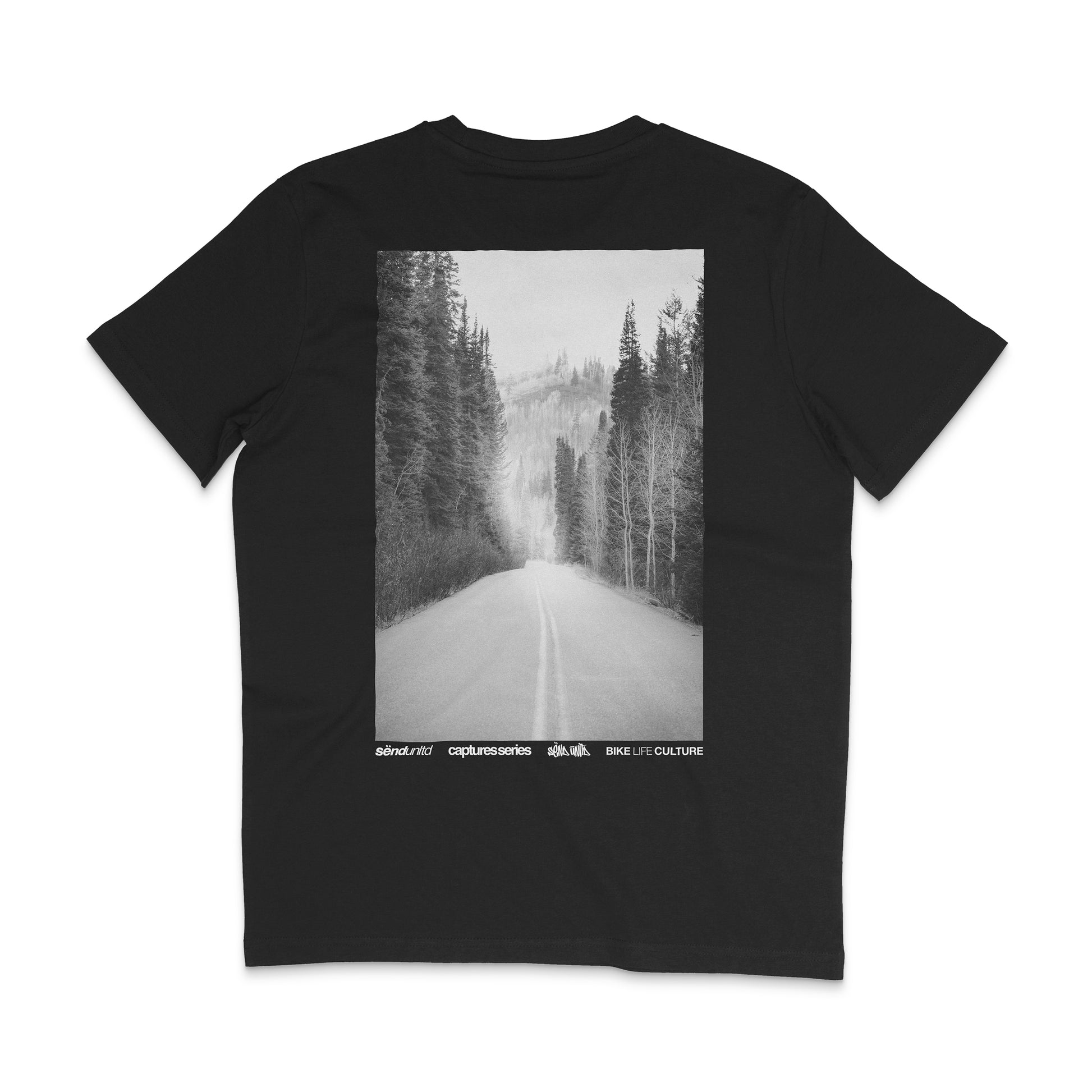 Backside of a black t-shirt with a large photo backprint of a mountain road at sunset 